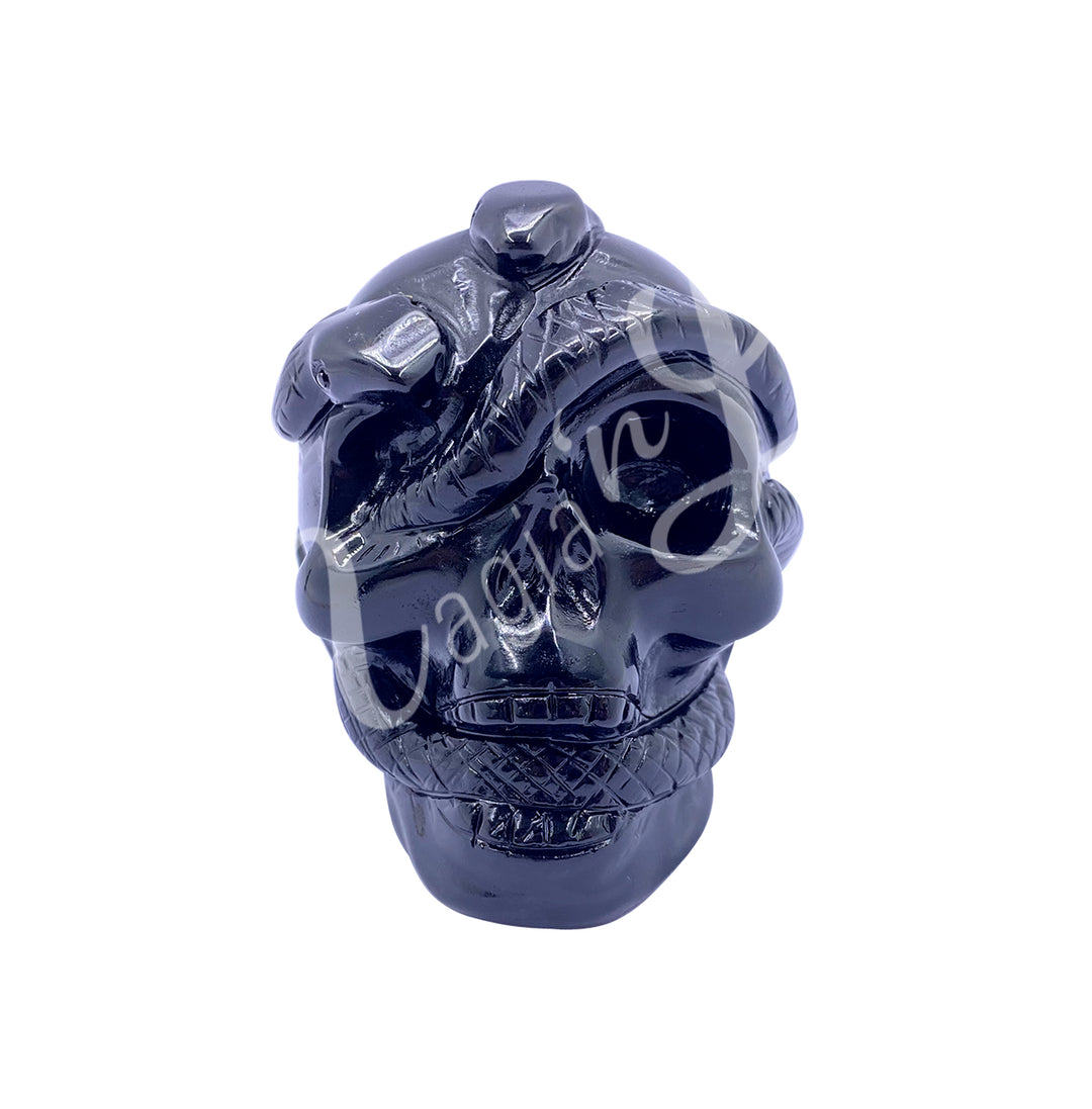 Polished gemstone skull with a snake carving made of black obsidian.