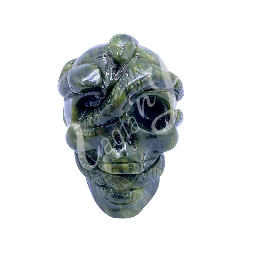 Polished gemstone skull with a snake carving made of serpentine.