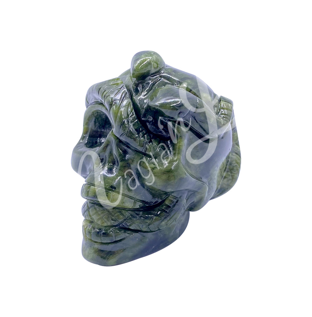 Polished gemstone skull with a snake carving made of serpentine. Seen with an angle.