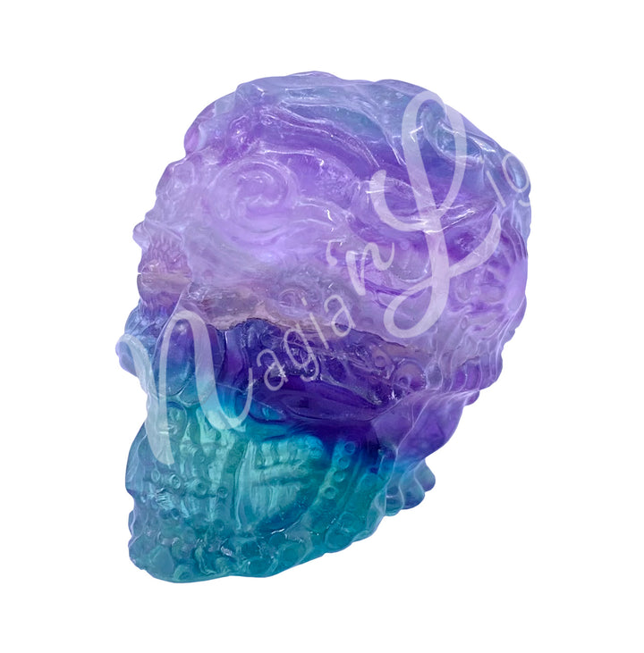 Polished gemstone skull with a design carving made of fluorite.