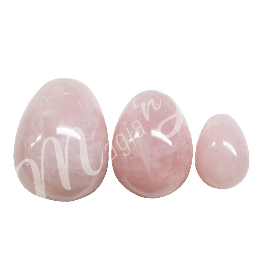 Three Rose Quartz eggs line from larger on the left to smallest on the right.