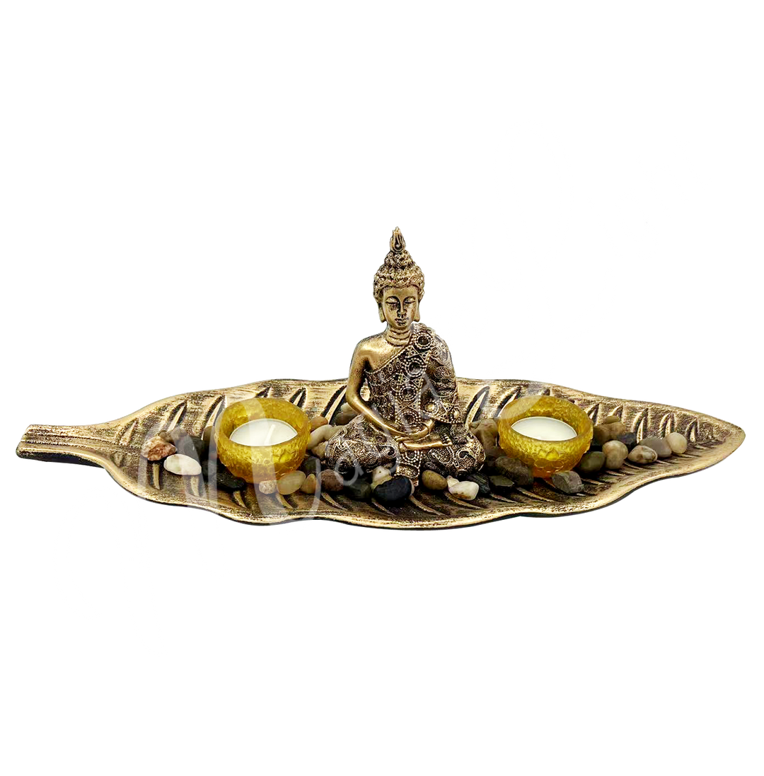 A tealight holder made of resin, featuring a Buddha seated in a leaf, with two tealight spaces beside him.