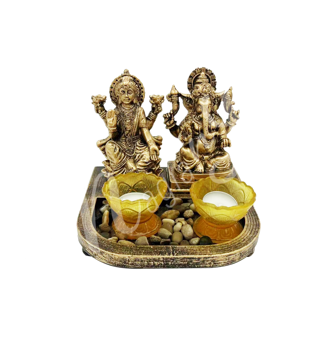 A resin tealight holder featuring the deities Ganesha and Lakshmi seated, with a lotus flower–shaped tealight space at the front.