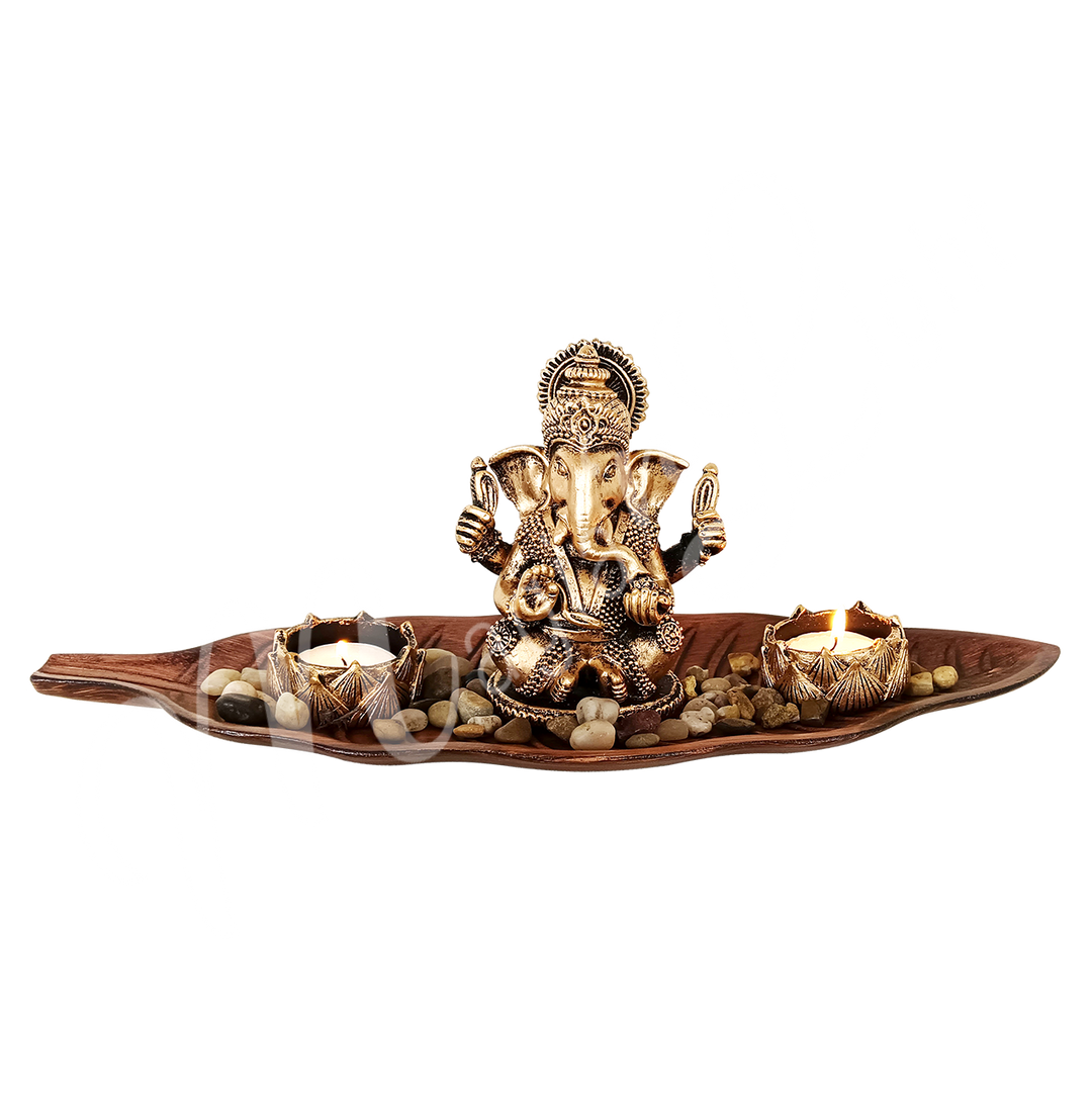 A resin tealight holder featuring the deity Ganesha seated in a wooden leaf, with a lotus flower–shaped tealight space beside him.