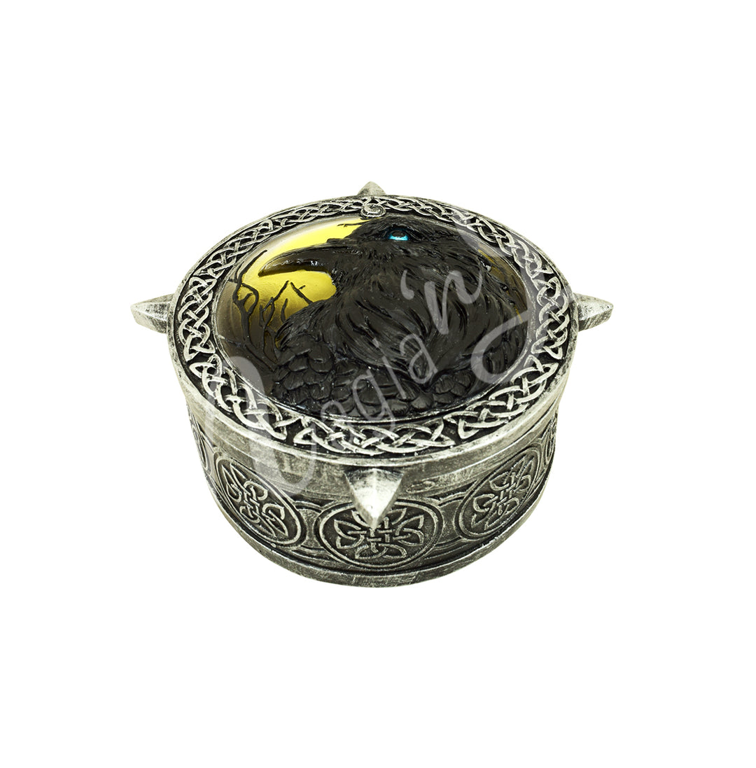 A round silver-toned box with Celtic knotwork designs and a raven on top.