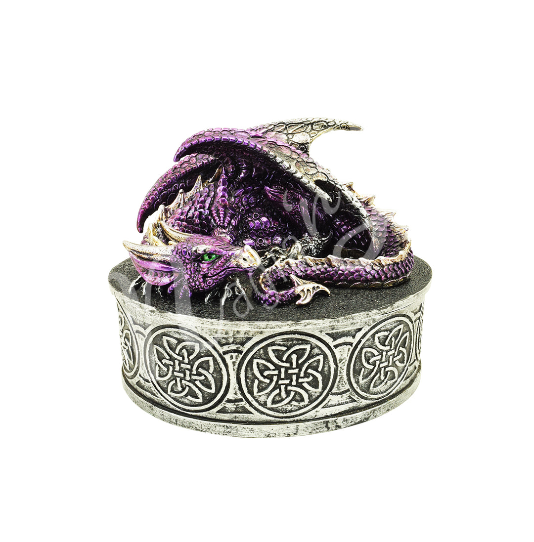 A round silver-toned box with Celtic knotwork designs. On top lies a curled, purple dragon with green eyes, detailed scales, and silver accents.