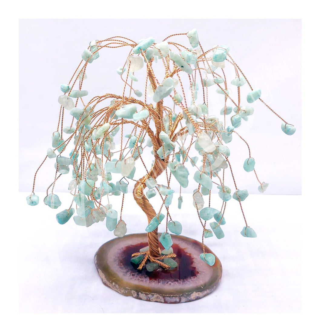 A wire gemstone bonsai tree with amazonie chips, mounted on a natural slice base.