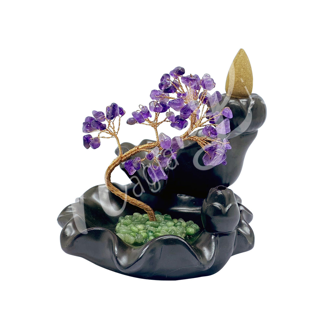 A gemstone bonsai tree with amethyst crystal chips, mounted on an ornate black dish that also functions as a backflow cone burner.