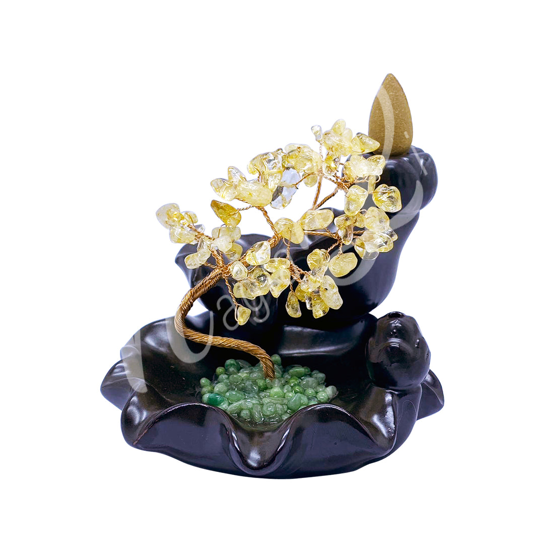 A gemstone bonsai tree with citrine crystal chips, mounted on an ornate black dish that also functions as a backflow cone burner.