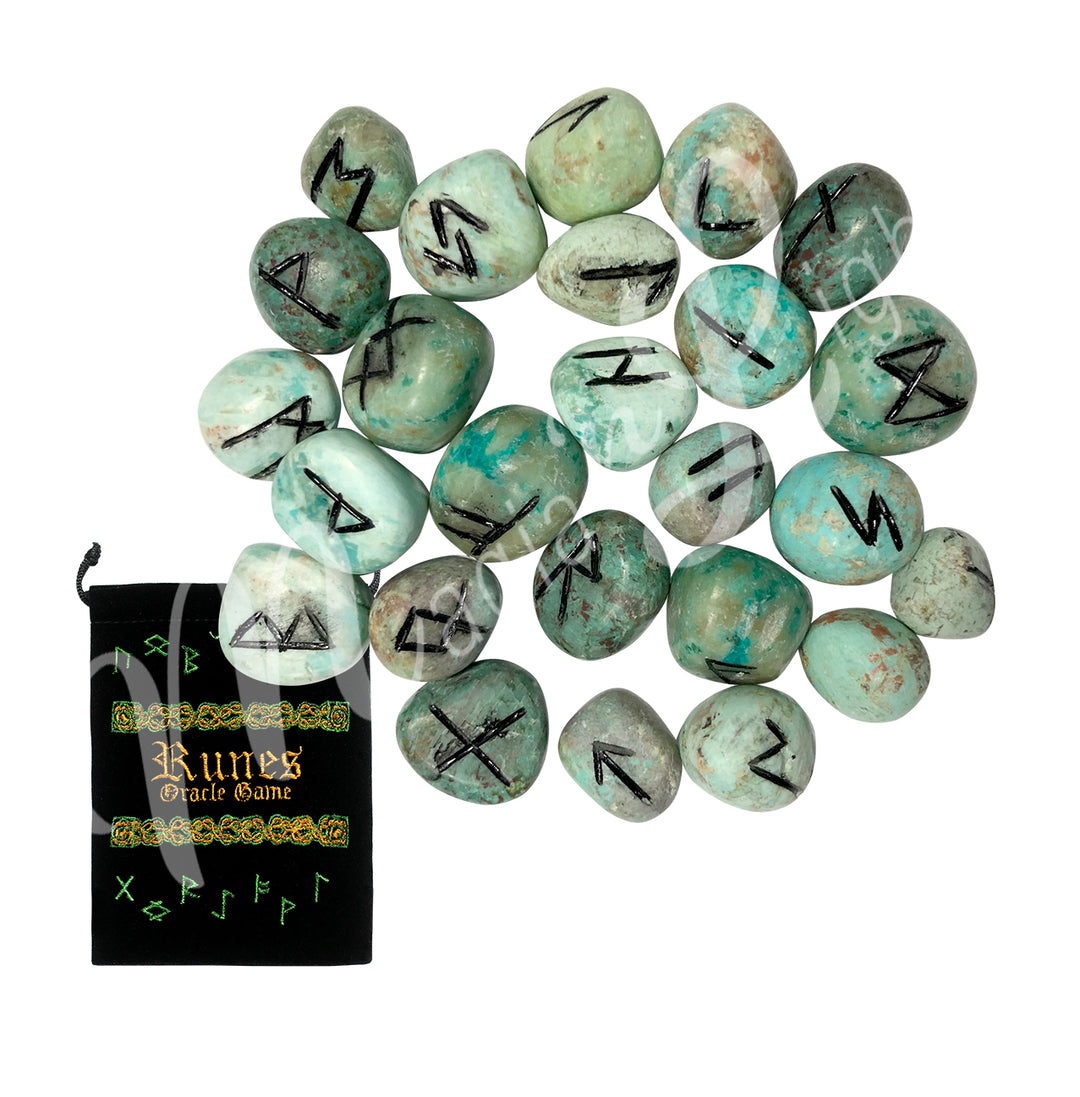 A set of turquoise runestones with engraved and painted black symbols, displayed with a black velvet pouch. The pouch is embroidered with the words "runes oracle game", as well as runic symbols.