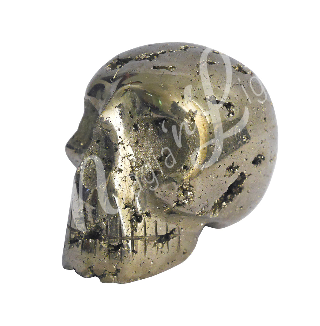 A polished pyrite skull carving, with natural holes revealing sparkling druzy crystals.