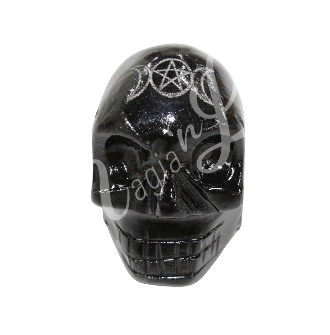 A polished skull carving made of smoky quartz, featuring an engraved triple moon with a pentacle at the center.
