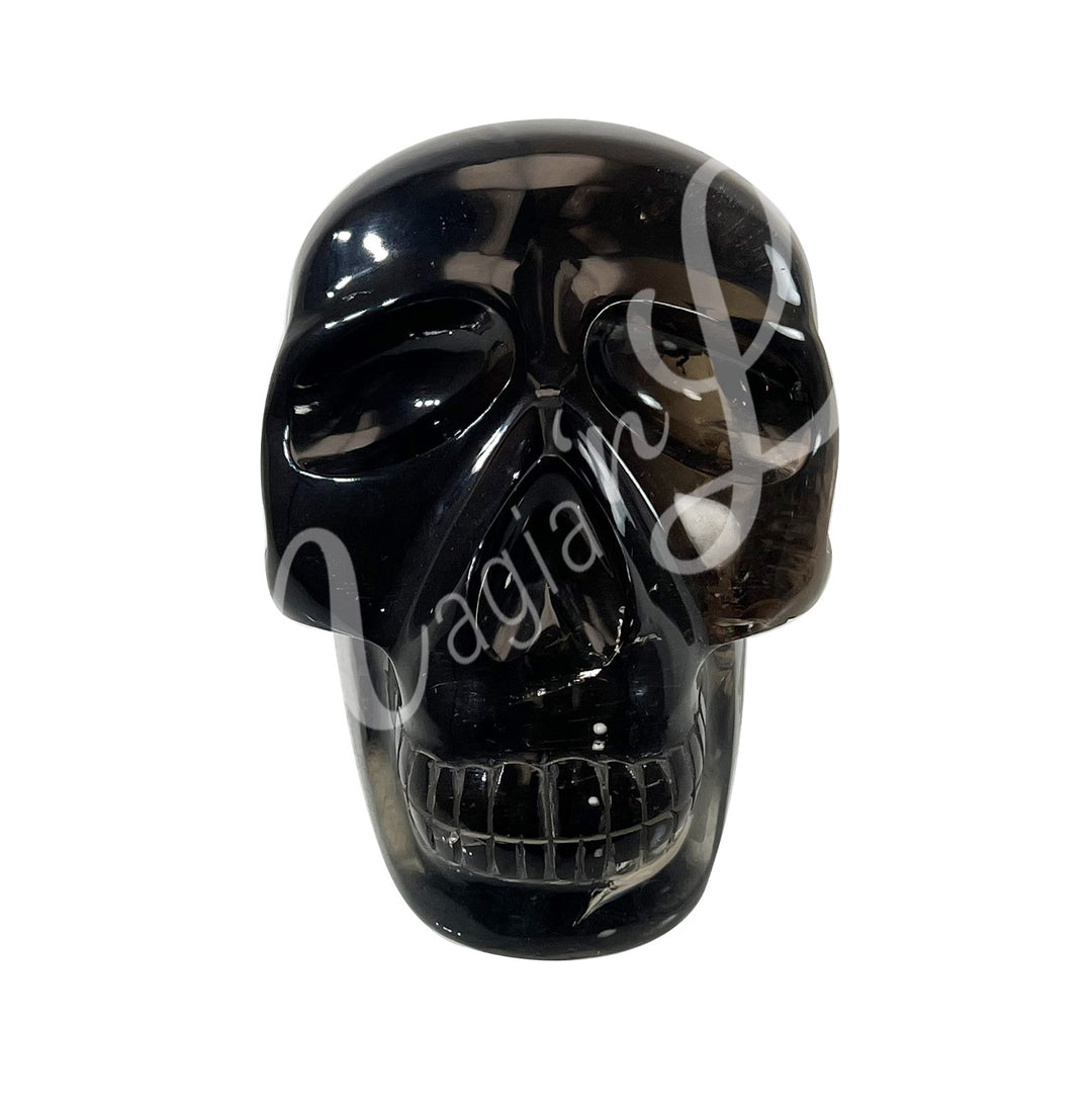 A polished skull carving with a visible crack, made of smoky quartz.