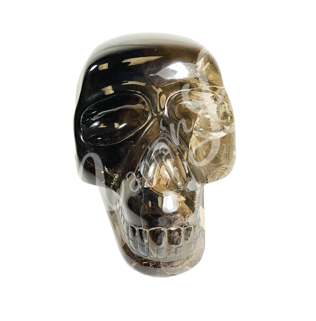 Polished gemstone skull carving made of smoky quartz.