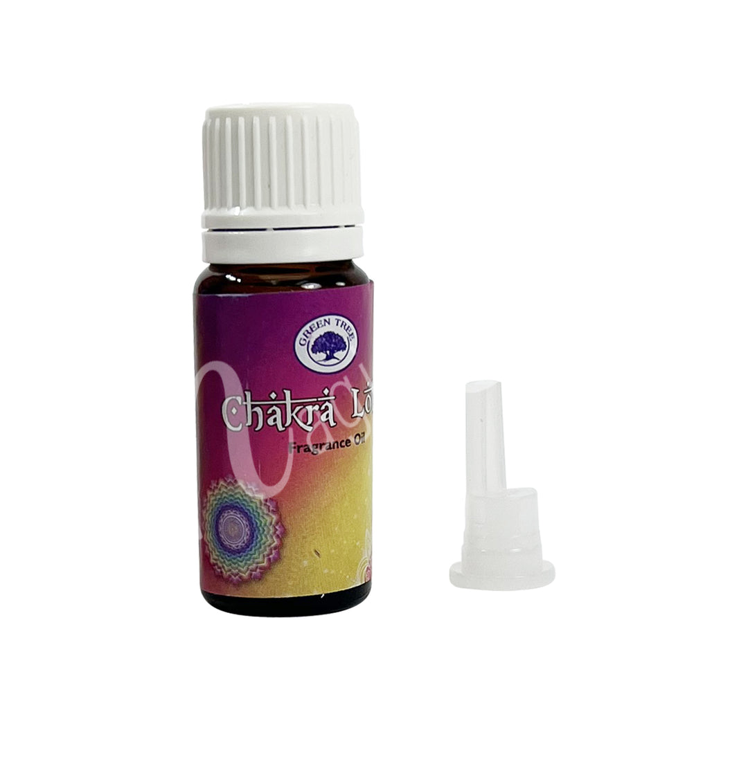 A bottle of Green Tree Chakra Lotus Fragrance Oil with a white cap and a dropper. The label features a colorful design with floral graphics and text.