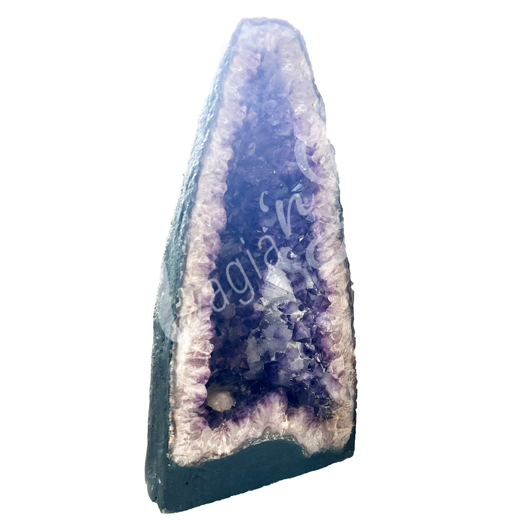 Side view of a long amethyst cathedral. The center is purple with glitter while the sides go from white to black on the exterior.