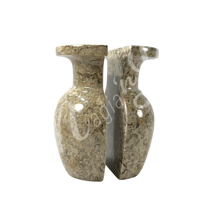 Two polished halves of a coral stone vase, positioned side by side to show the split down the middle, with a rounded body, narrow neck, and flared rim.