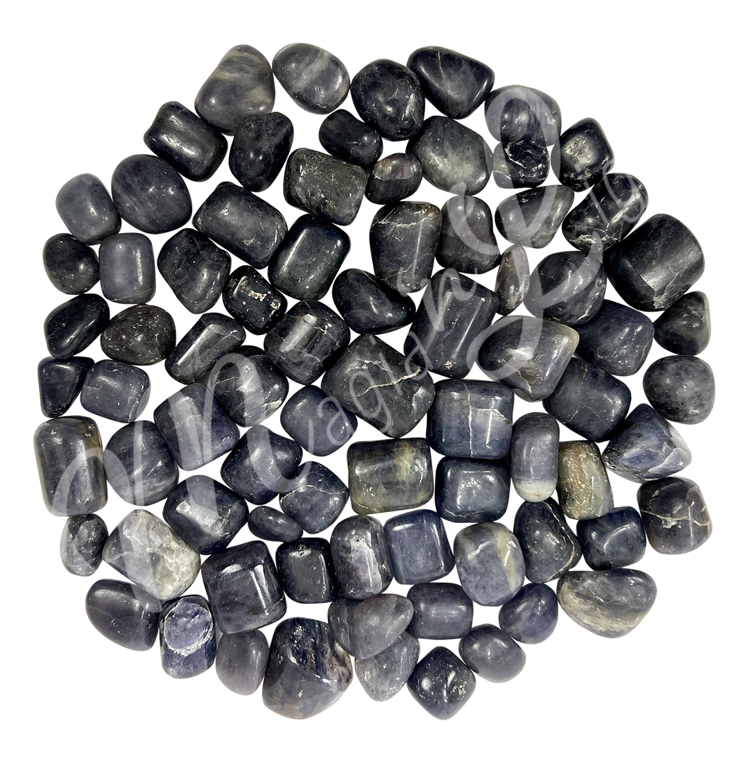 Collection of polished tumbled stones in shades of green, purple, blue, and black, arranged together in a circular pile.