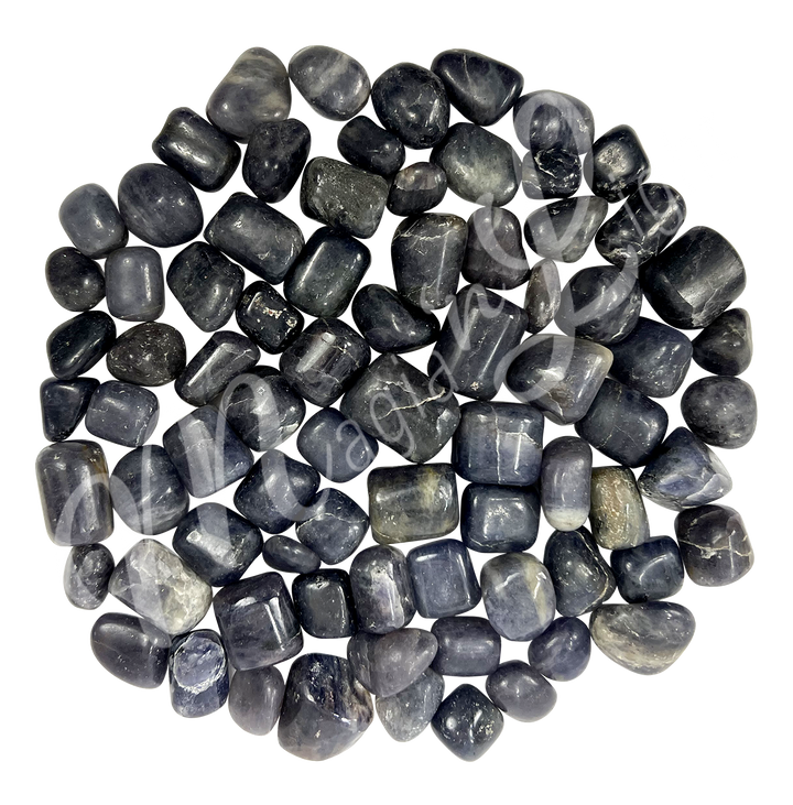 Collection of polished tumbled stones in shades of green, purple, blue, and black, arranged together in a circular pile.