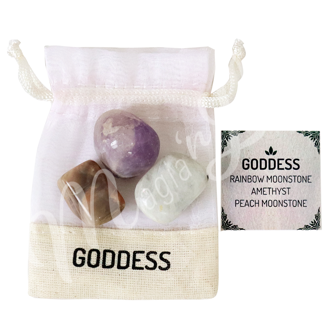 A white drawstring pouch labeled “GODDESS” displayed with three polished stones—Rainbow Moonstone, Amethyst, and Peach Moonstone—alongside a tag that reads “GODDESS: Rainbow Moonstone, Amethyst, Peach Moonstone.”