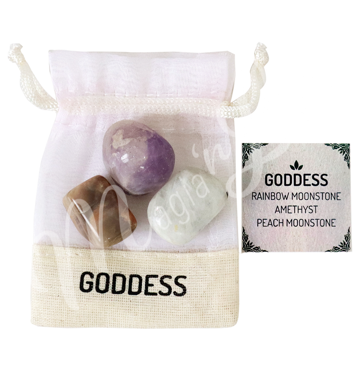 A white drawstring pouch labeled “GODDESS” displayed with three polished stones—Rainbow Moonstone, Amethyst, and Peach Moonstone—alongside a tag that reads “GODDESS: Rainbow Moonstone, Amethyst, Peach Moonstone.”