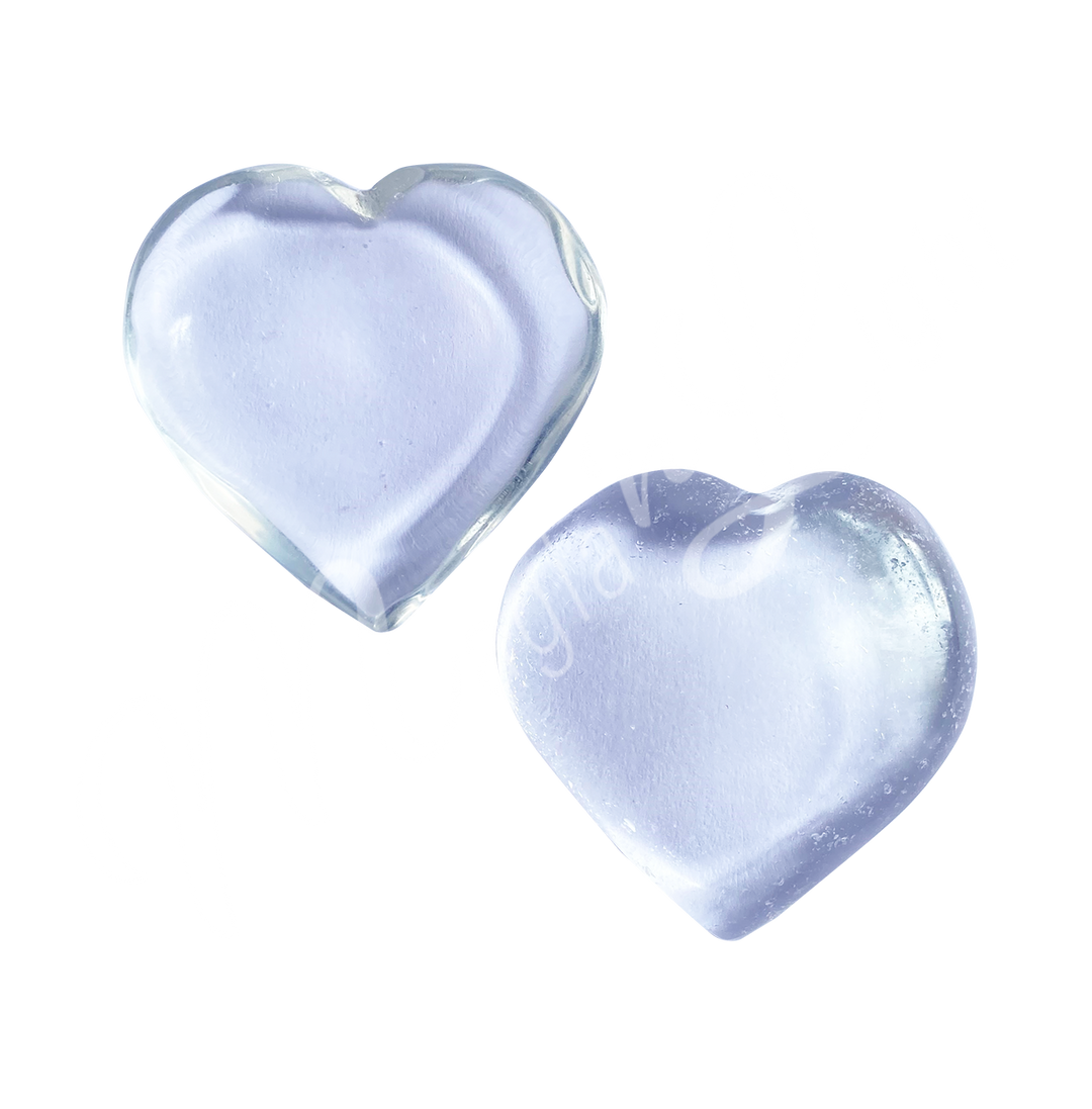 Two polished clear heart-shaped stones with a smooth, glossy surface. The stones are translucent and reflect light, giving them a soft, radiant appearance.