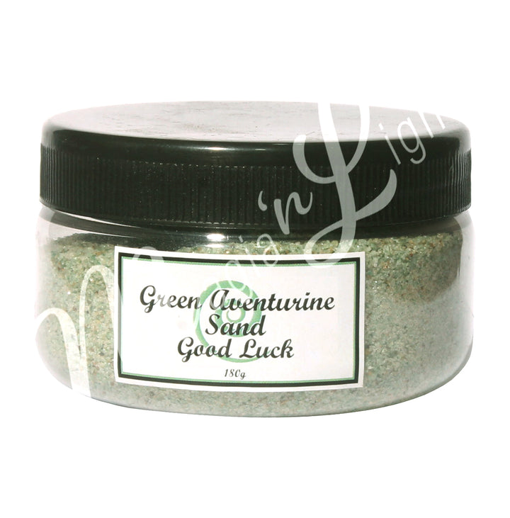 Clear plastic jar with a black lid containing green stone sand. The label reads “Green Aventurine Sand – Good Luck, 180 g.”