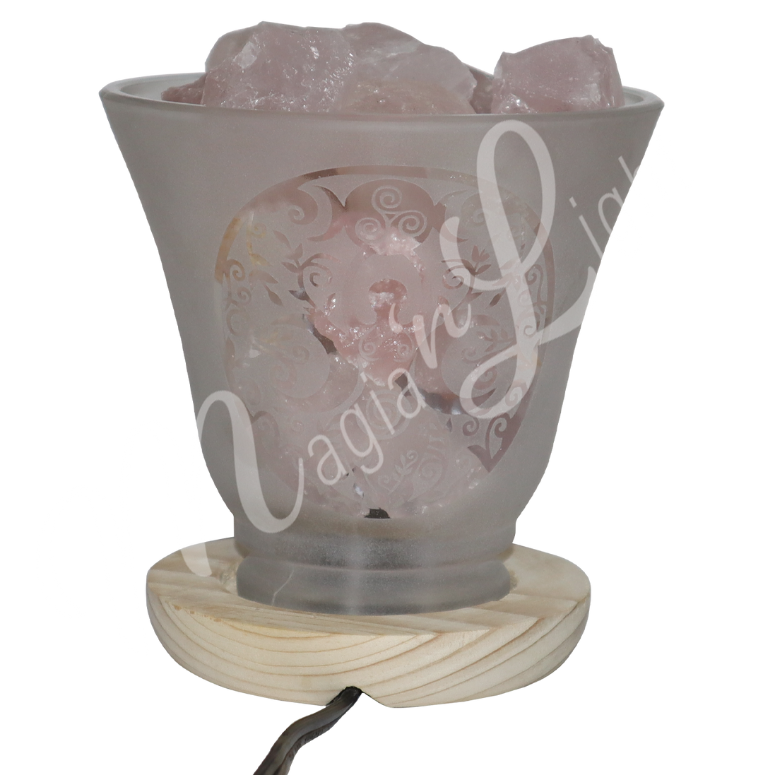 Decorative frosted glass lamp with etched Goddess design, wooden base, and filled with rose quartz crystals.