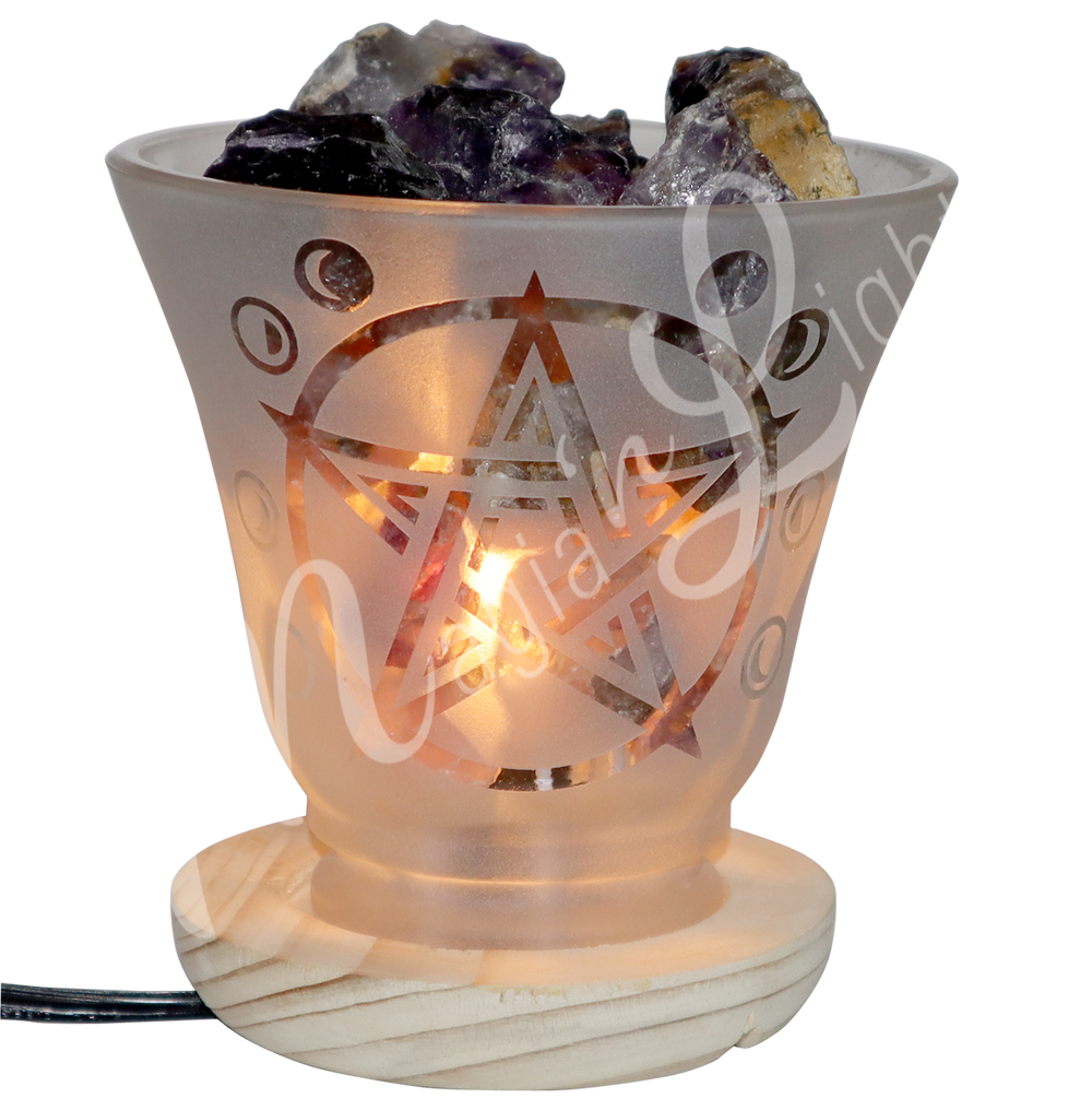 Lit decorative frosted glass lamp with etched pentacle design, wooden base, and amethyst crystals glowing warmly.