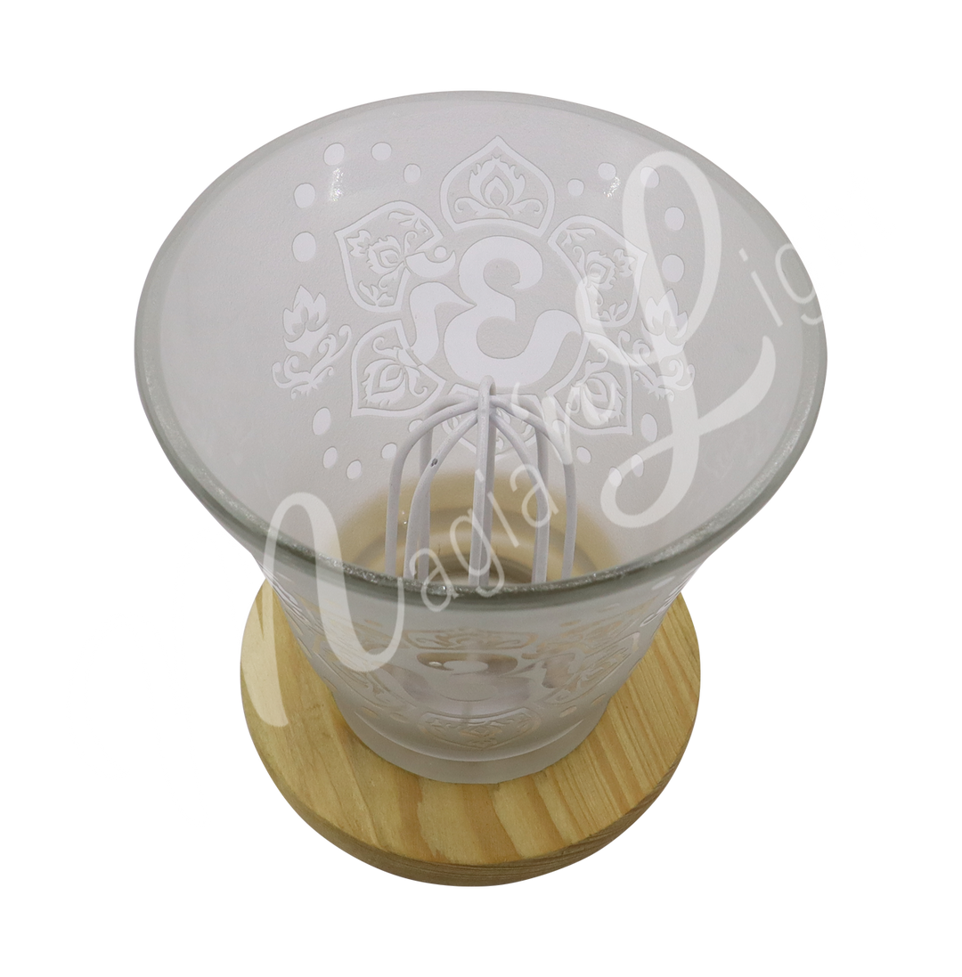 Empty decorative frosted glass cup lamp with etched Om in a lotus flower design, wooden base, metal piece in the middle.