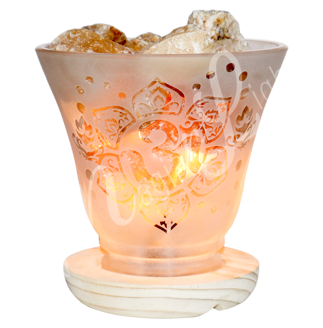 Lit decorative frosted glass lamp with etched Om in a lotus flower design, wooden base, and citrine crystals glowing warmly.