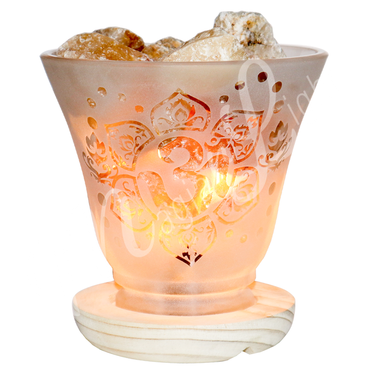 Lit decorative frosted glass lamp with etched Om in a lotus flower design, wooden base, and citrine crystals glowing warmly.