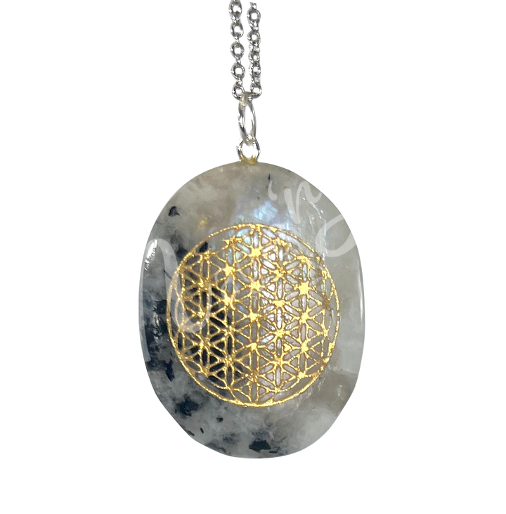 A pendant worry stone made of Rainbow Moonstone with a geometric Flower of Life pattern engraved on it