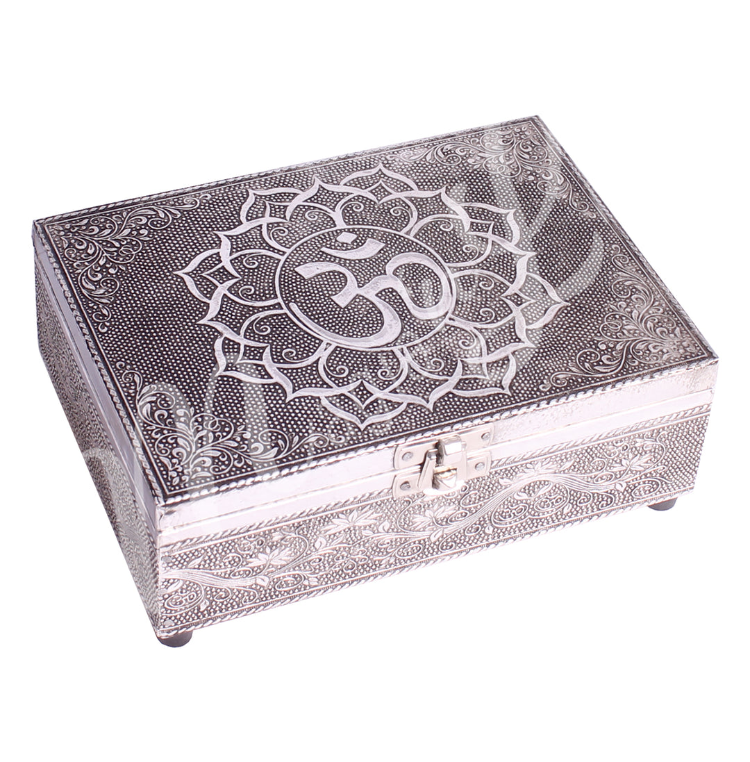 A metal box features an OM in a lotus flower design on the lid.