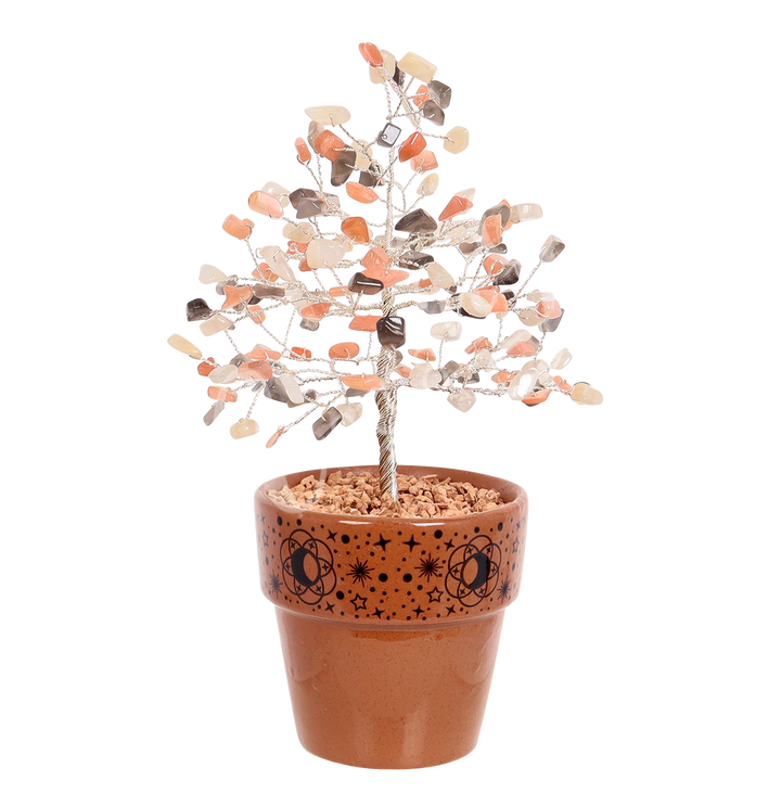 A gemstone bonsai tree with branches made of wire and decorated with multi moonstone chips, set in a terracotta pot decorated with moon, stars and sun designs.