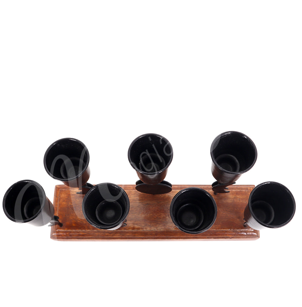 An iron moon phase mini candle holder on wooden base, designed to hold seven candles, seen from the top.
