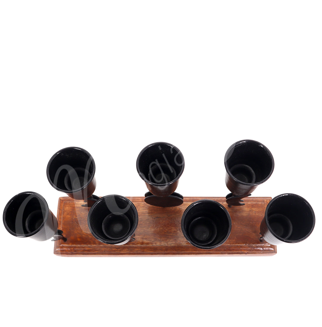An iron moon phase mini candle holder on wooden base, designed to hold seven candles, seen from the top.
