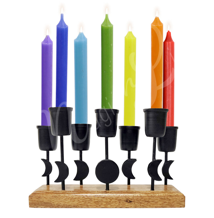 An iron moon phase mini candle holder on wooden base, holding seven candles.