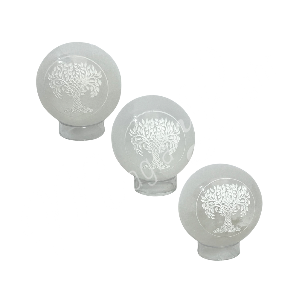 Three clear glass sphere with a tree of life symbol engraved and painted white on stand.