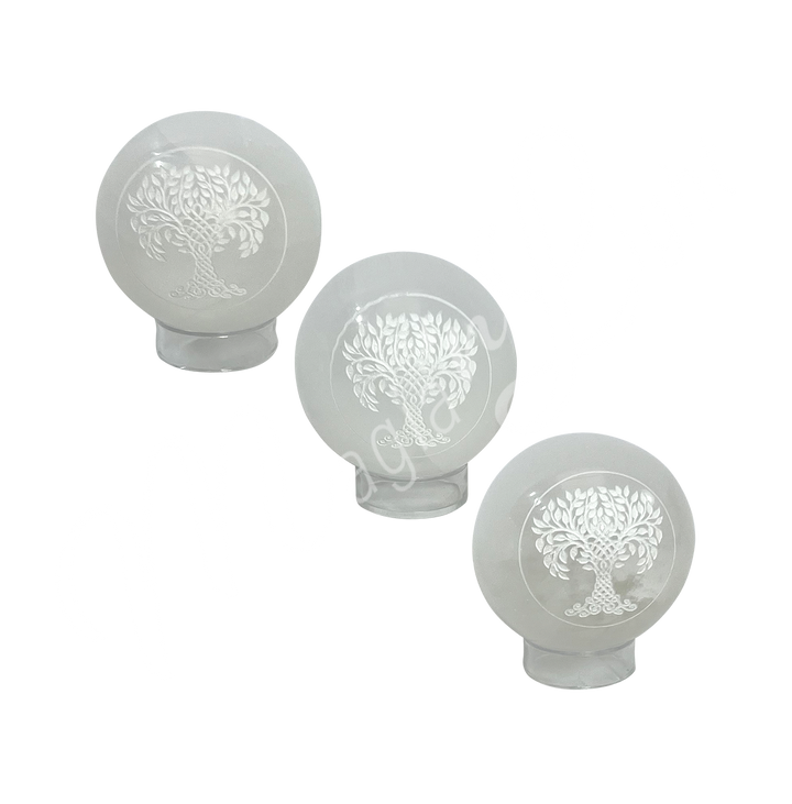 Three clear glass sphere with a tree of life symbol engraved and painted white on stand.