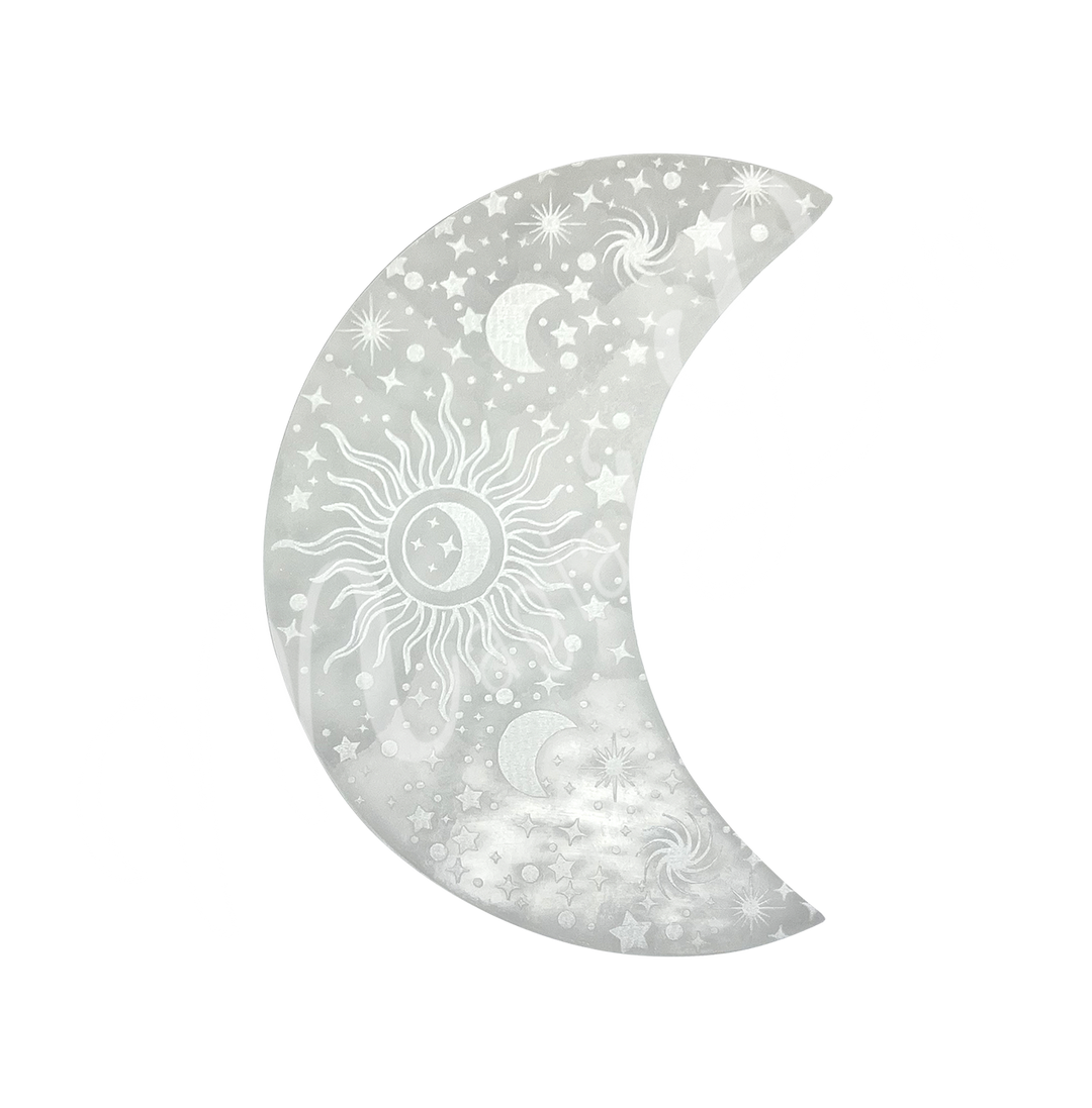 A moon-shaped Selenite crystal engraved with stars, crescent moons, a central sun, and spiral galaxy designs.