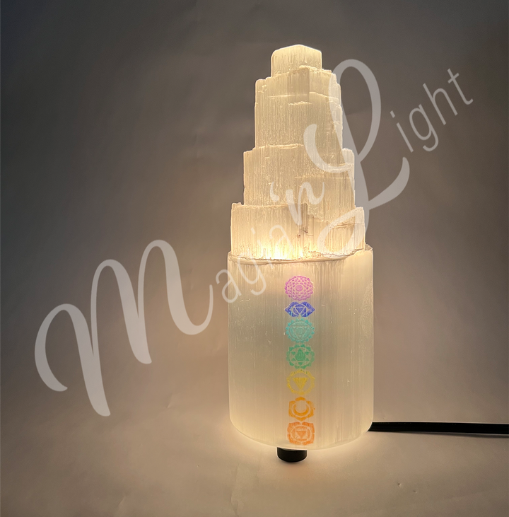 Selenite iceberg carving with black rubber feet. The lamp is engraved of the chakra symbol, glowing in the dark.