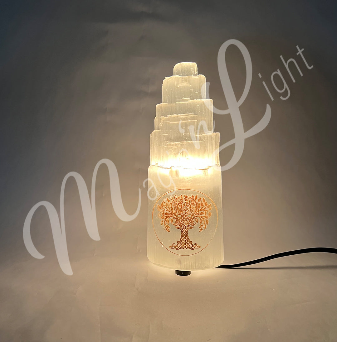 Selenite iceberg carving with white rubber feet. The lamp is engraved with a gold Tree of Life, glowing in the dark.