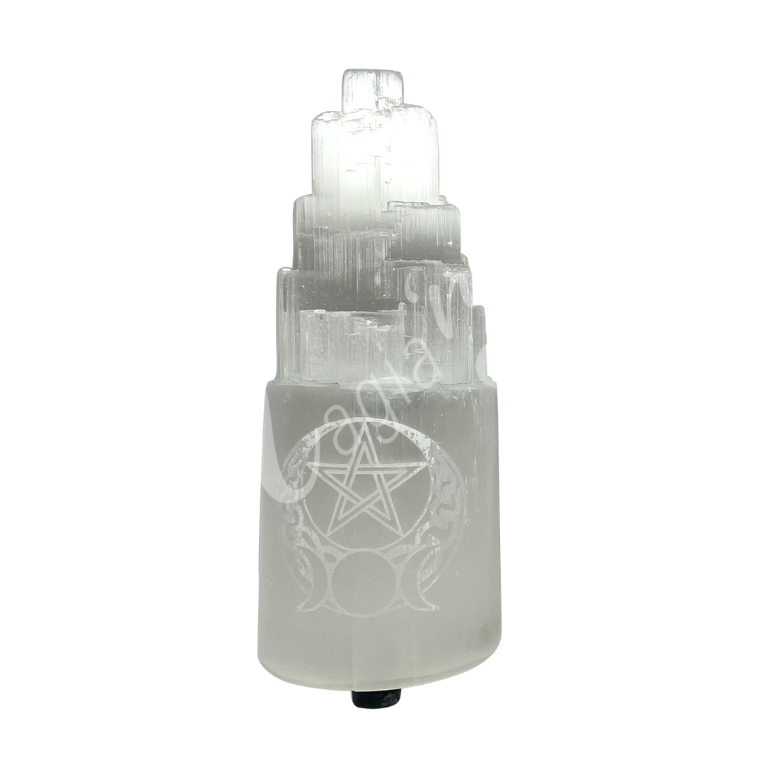 Selenite iceberg carving with black rubber feet. The lamp is engraved with a white triple moon and a pentacle, seen with an other angle.