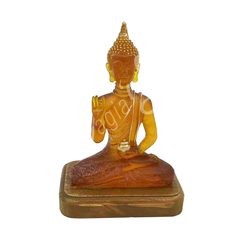 A resin lamp and statue representing the deity Buddha with one hand raised, set on a wooden base.