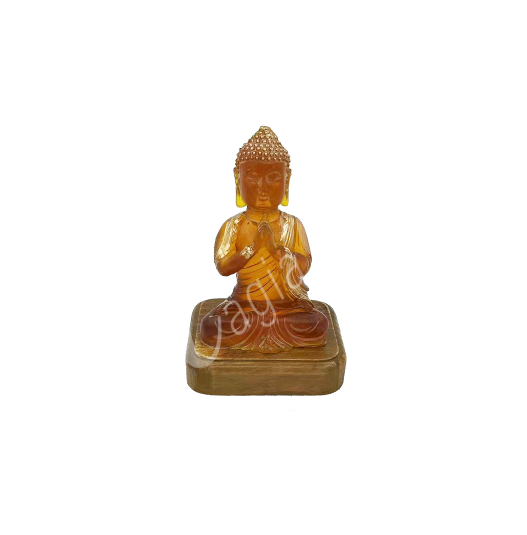 A resin lamp and statue representing the deity Buddha in meditation, set on a wooden base.