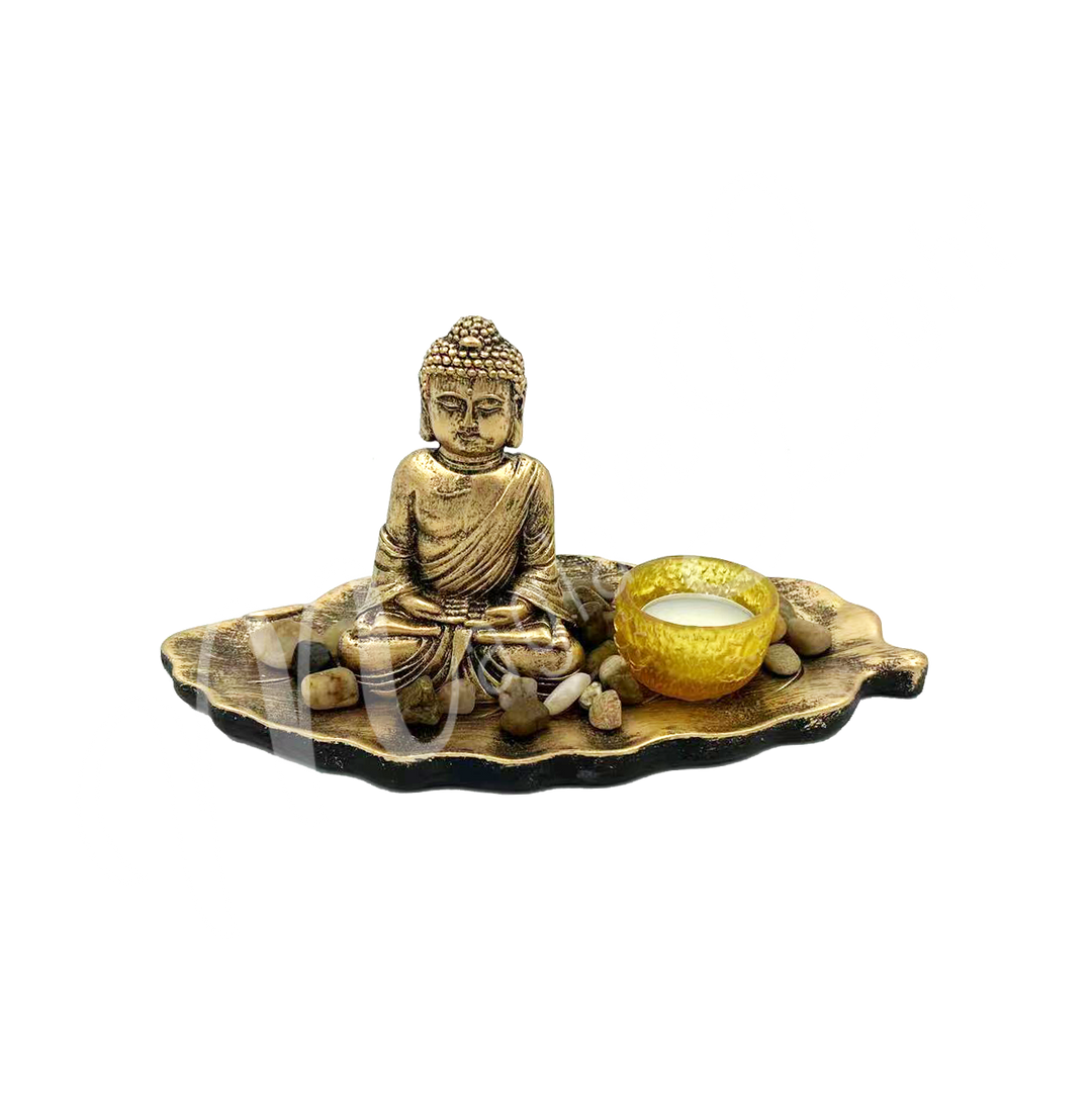 A tealight holder made of resin, featuring a Buddha seated in a leaf, with the tealight space beside him.