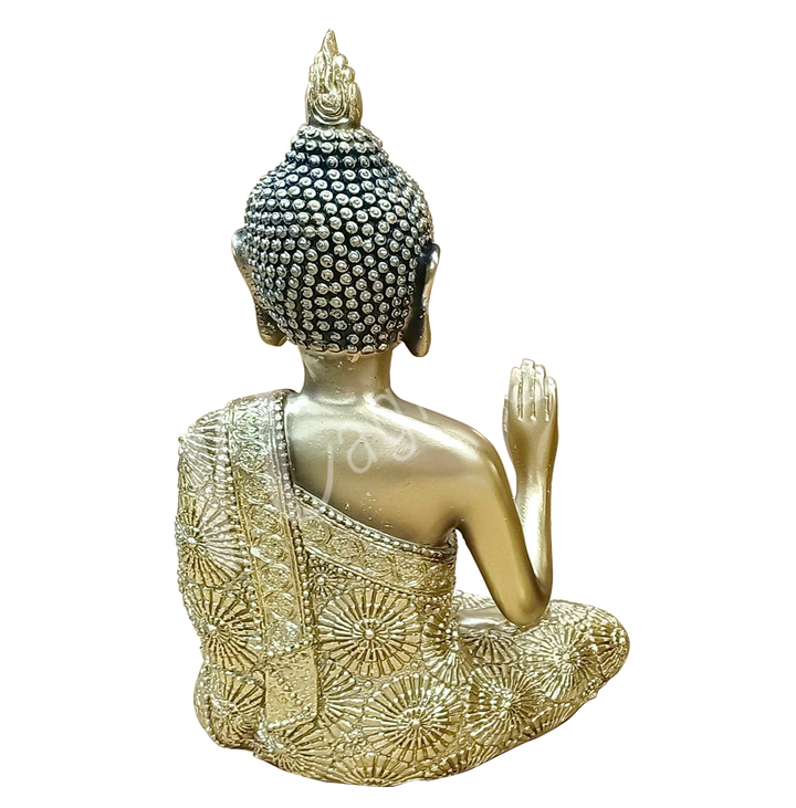 An antique gold-colored resin statue featuring a seated Buddha with a raised hand, seen from the back.