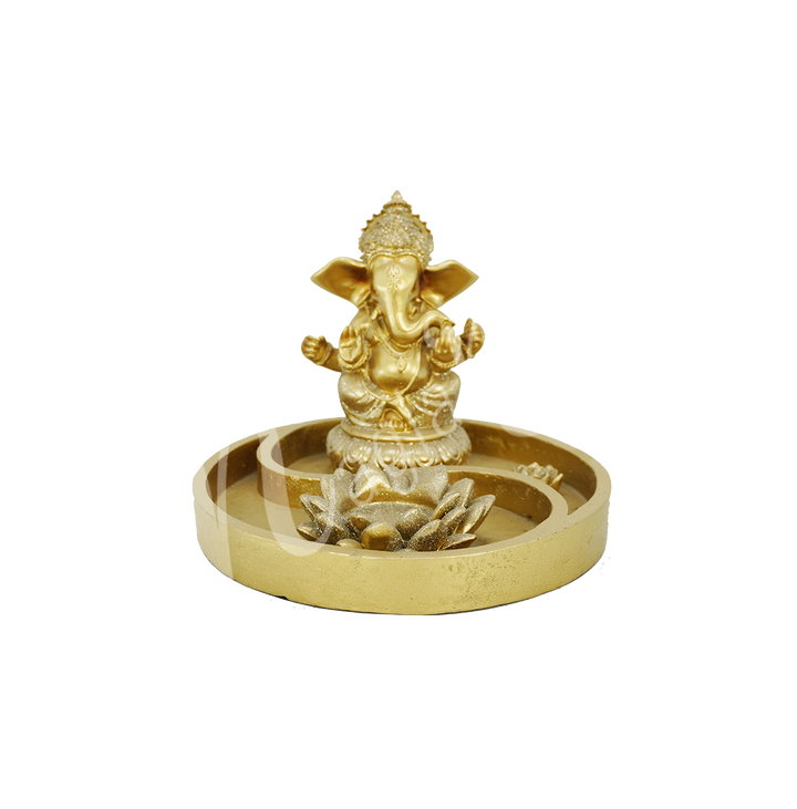 A Yin Yang gold-colored tealight and incense holder made of resin, featuring the deity Ganesha at the back, with tealight and incense spaces at the front.