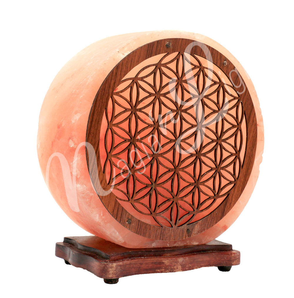 Angled view of a round Himalayan salt lamp mounted on a dark wooden base. The front is decorated with a flower of Life design wooden panel.